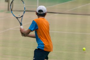 テニスのスイングする学生
