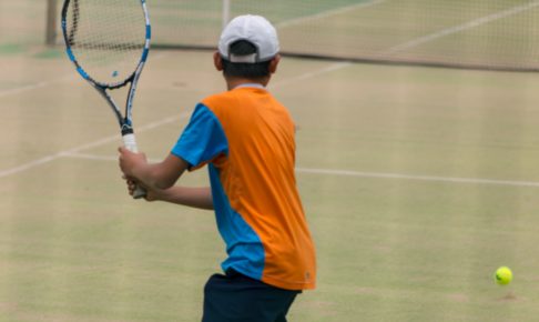 テニスのスイングする学生